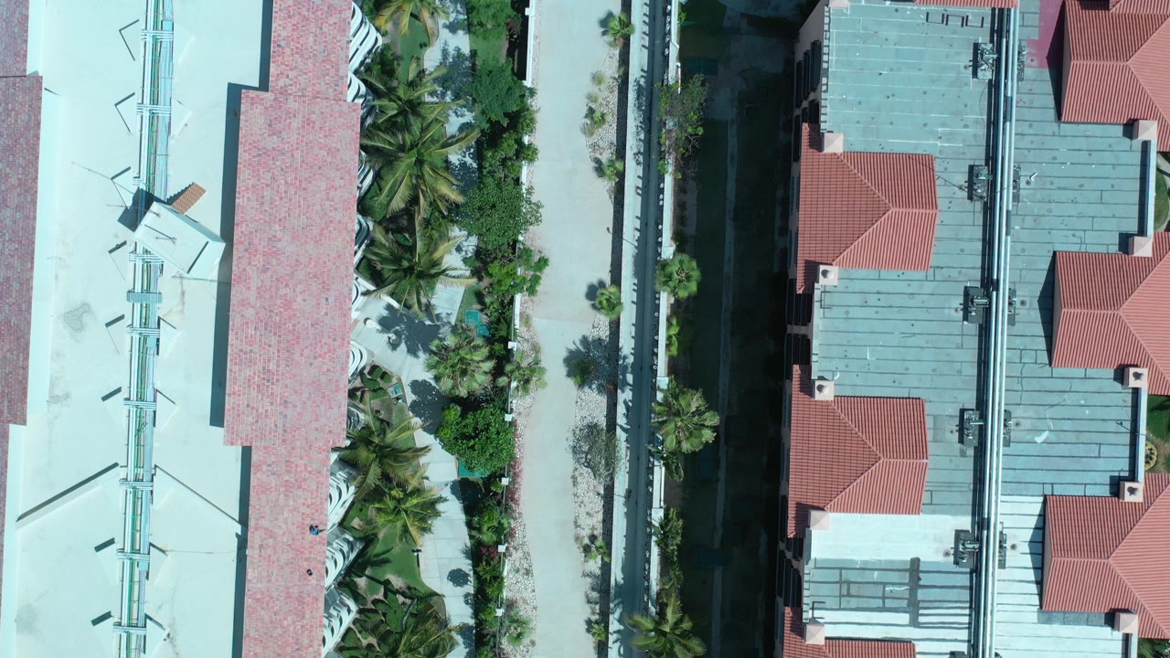 Top-down view of resort roofs, palms, and walkways.