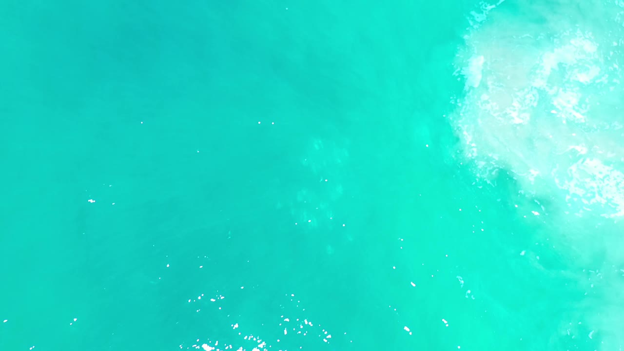 Overhead Los Cabos sea water frame with mostly open turquoise surface, scattered white ripples, and no visible people.