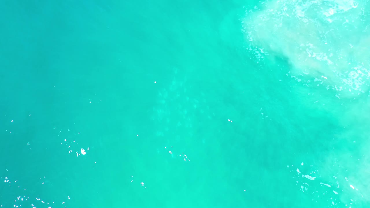 Turquoise water with brighter foam entering near the top