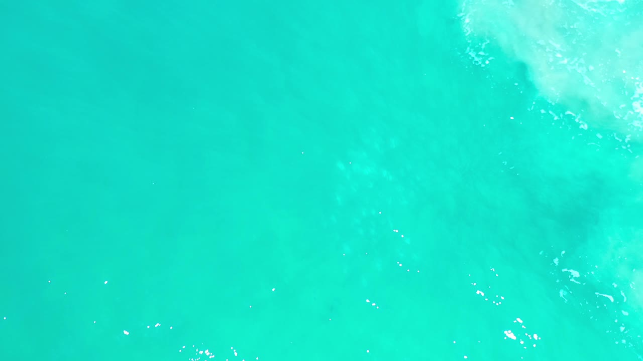 Turquoise water with a brighter patch of wave wash in the upper right.