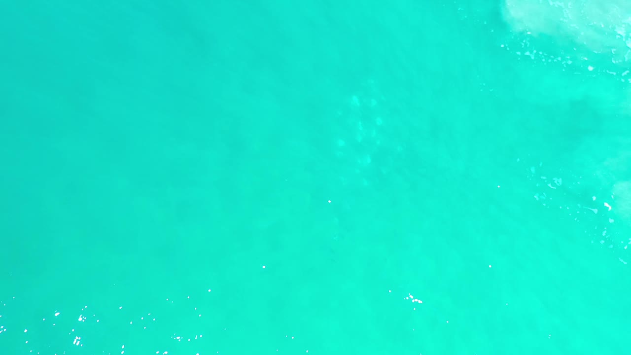 Light green sea water fills the frame in Los Cabos, Mexico, with soft ripple texture and no visible people.