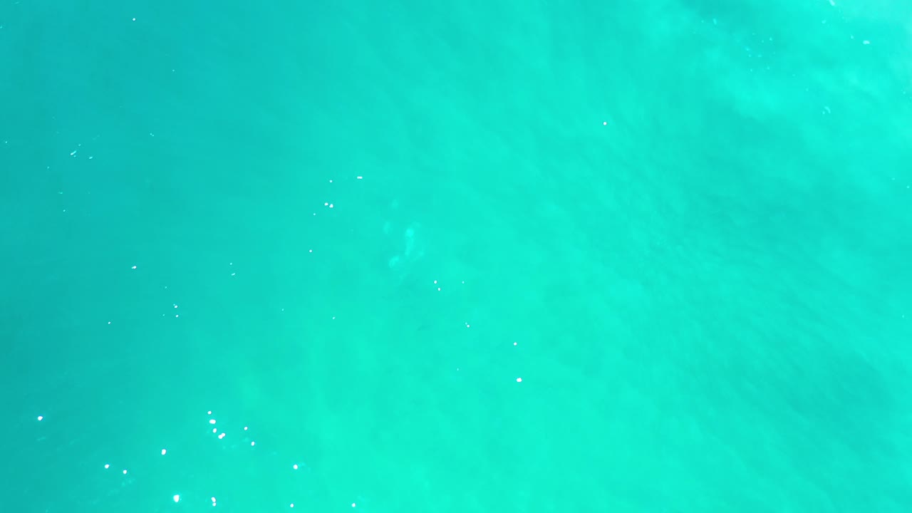 Overhead view of turquoise sea water in Los Cabos, Mexico, with faint pale underwater patches and no visible people.