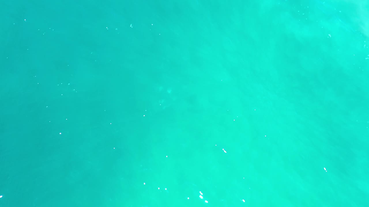 Bright turquoise ocean water with pale areas