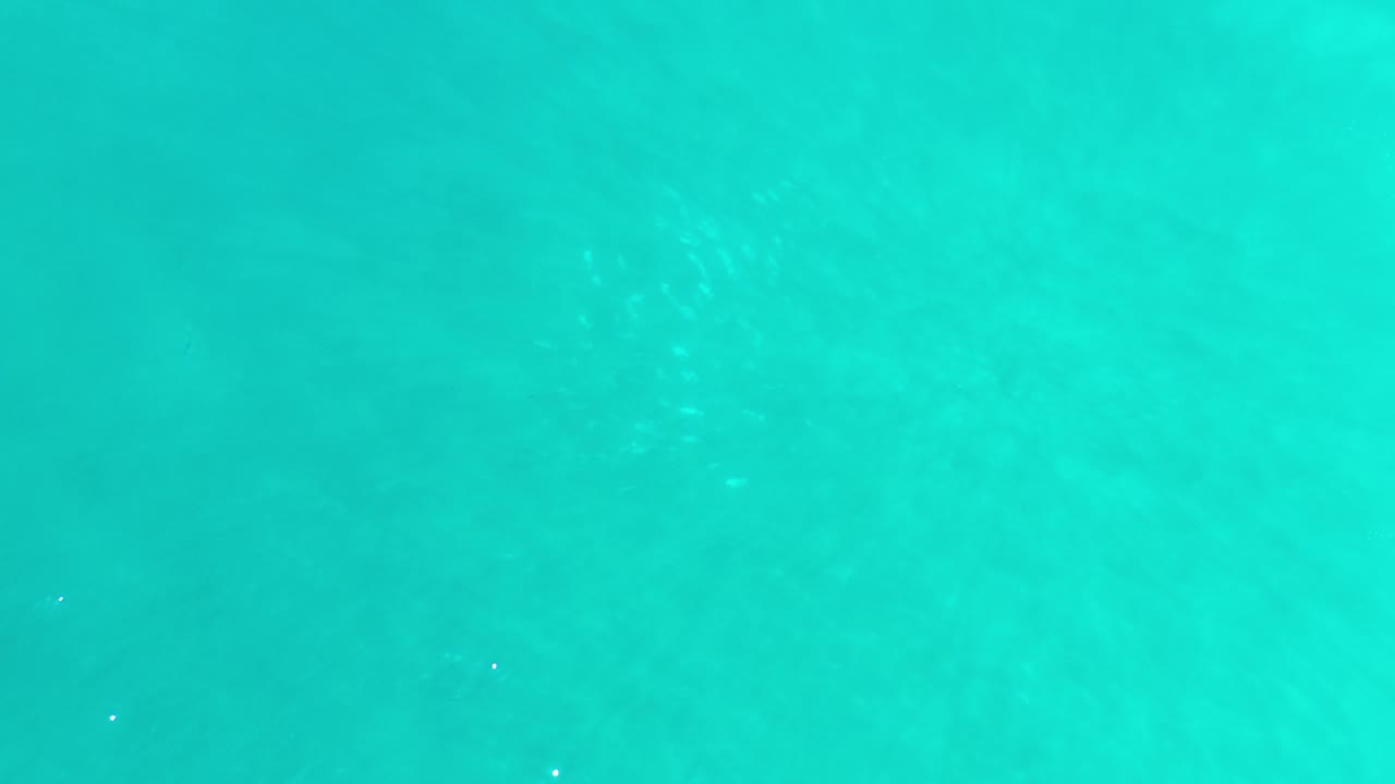 Turquoise ocean water in Los Cabos fills the frame with faint surface ripples and no visible people.