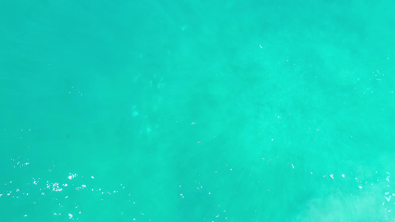 Clear teal water with sparse white sparkle.