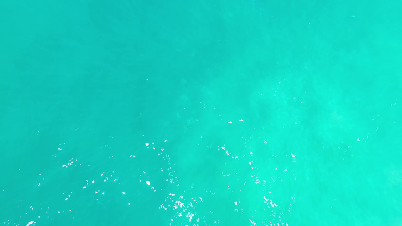 Green ocean water in Los Cabos remains full frame, with soft ripples, faint darker patches below the surface, and no visible people.