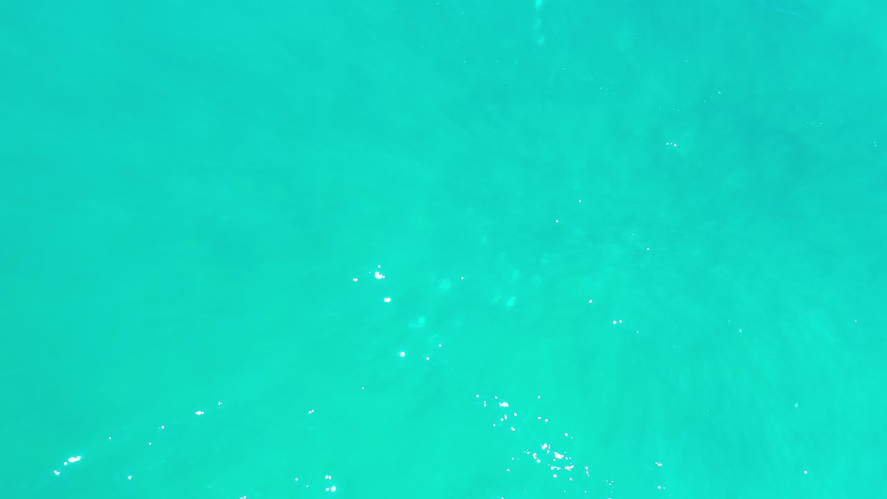 Turquoise water surface with small white ripple highlights