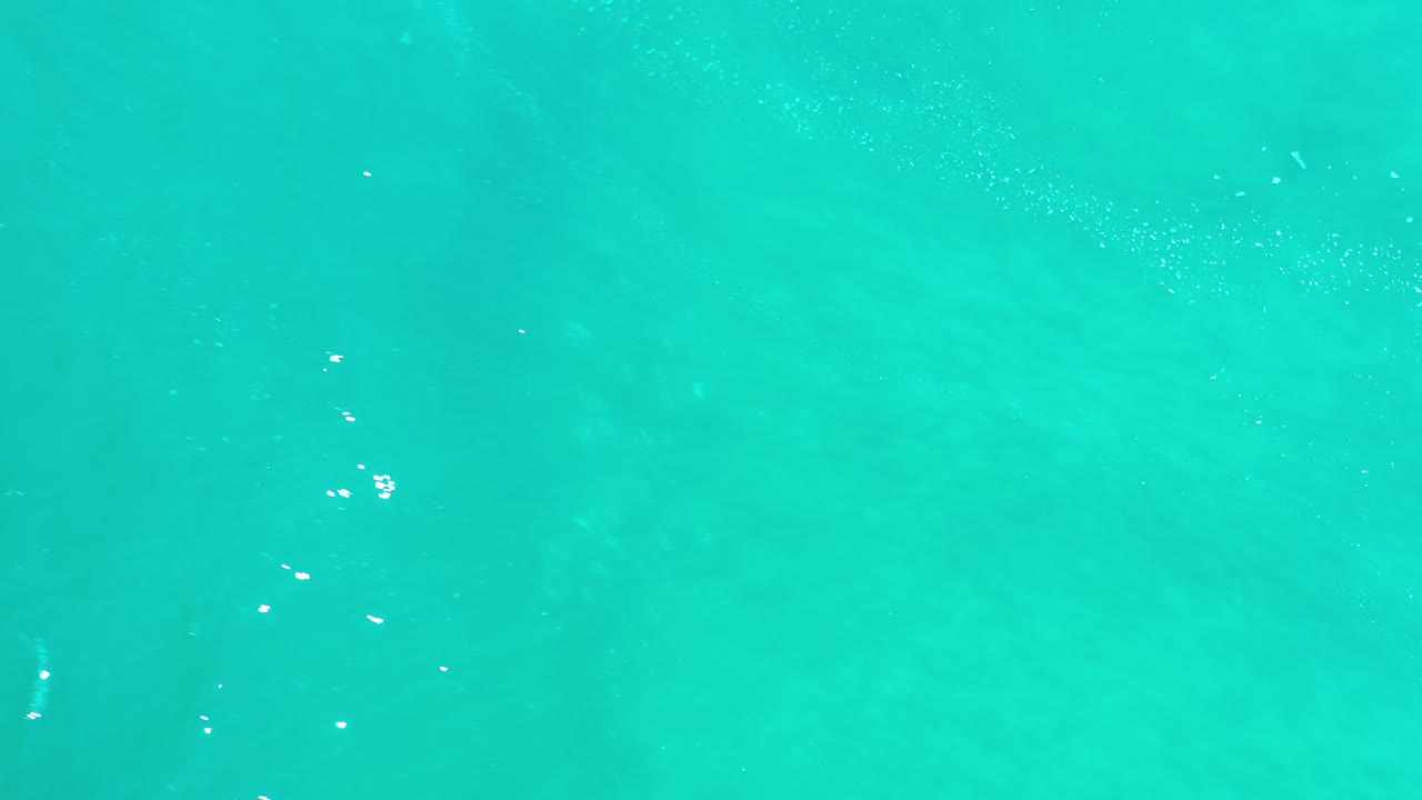 Turquoise water with a soft foamy streak near the lower edge.