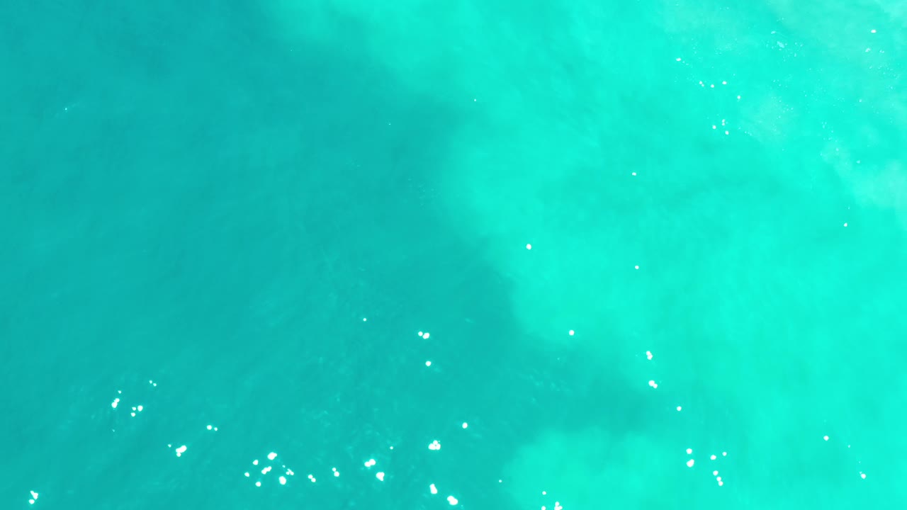 Bright turquoise water with small white reflections across the surface.