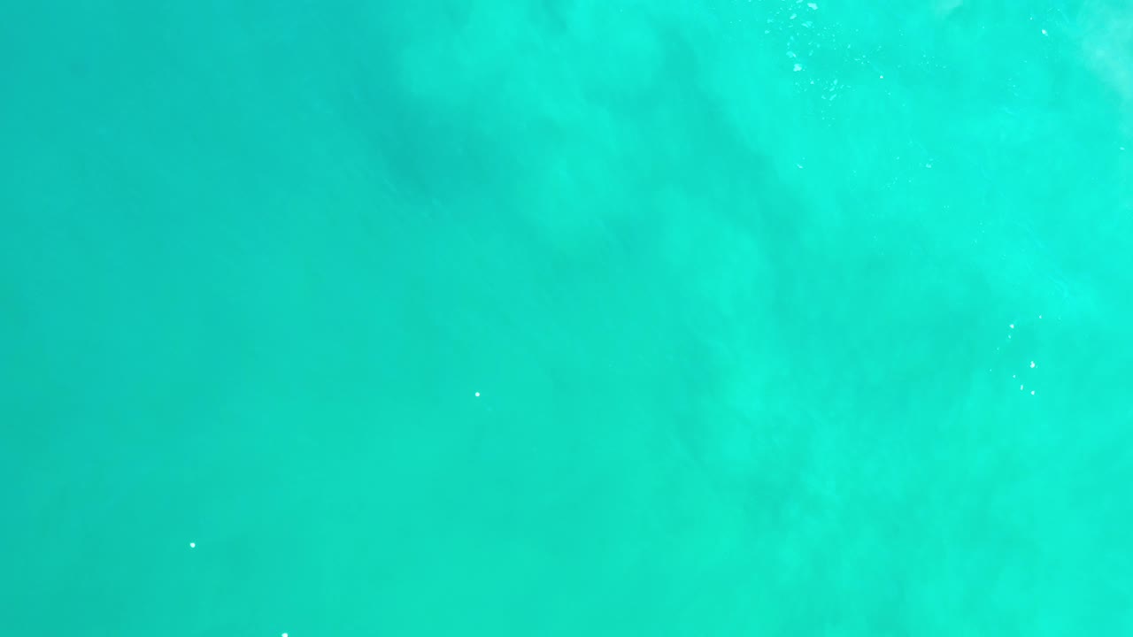 Aqua ocean surface with soft darker patches