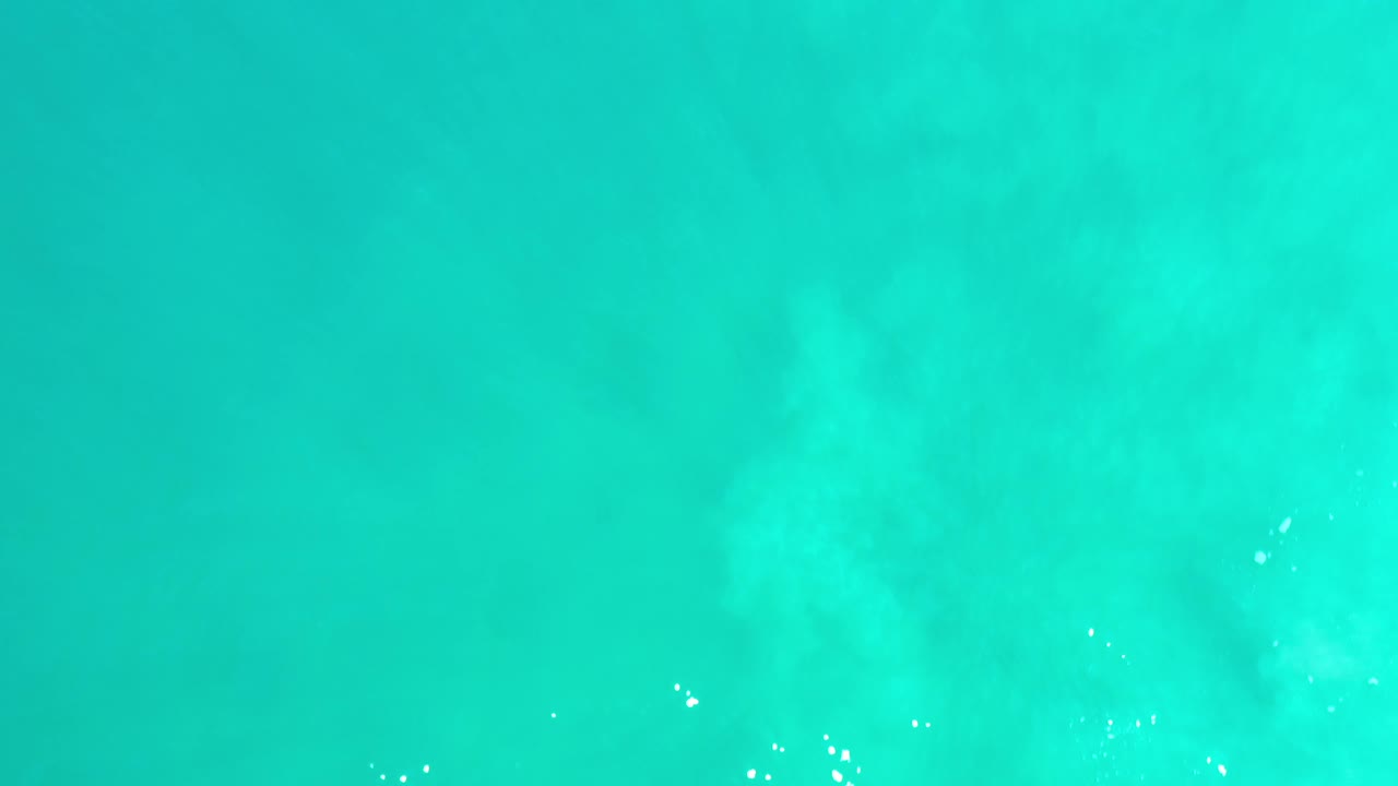 Second frame of Los Cabos abstract water, showing a brighter aqua field with soft blue-green clouding, scattered white glints, and no visible people.