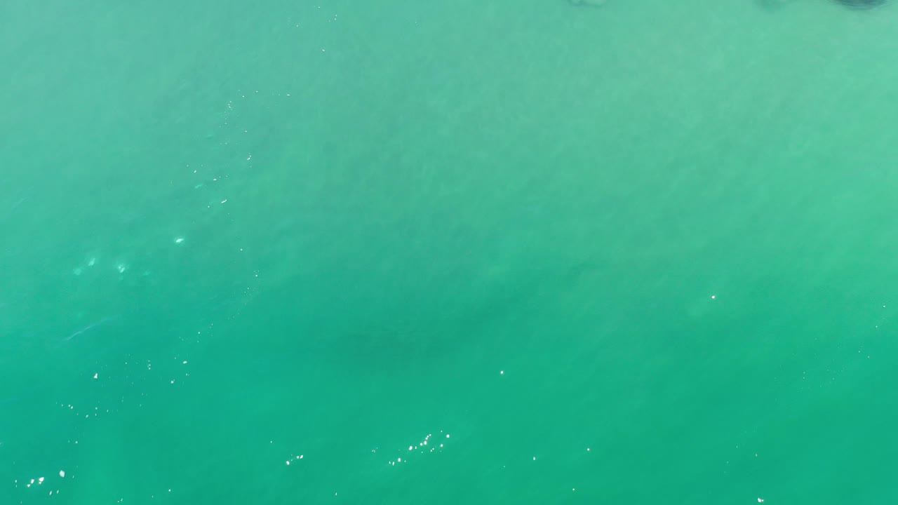 Aerial ocean water with faint texture and darker patches.
