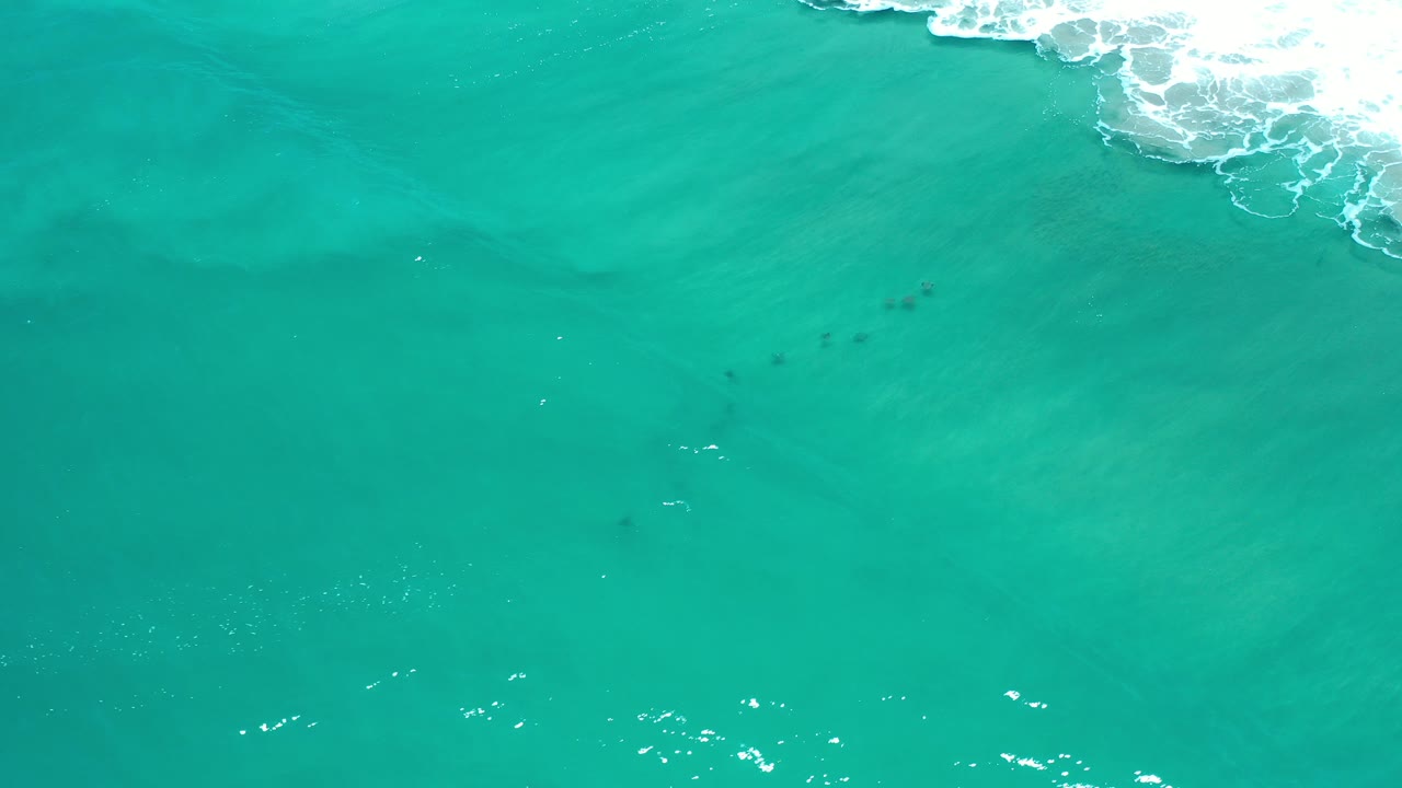Overhead view of turquoise ocean water in Los Cabos, Mexico, with white surf touching the upper right edge and no visible people.