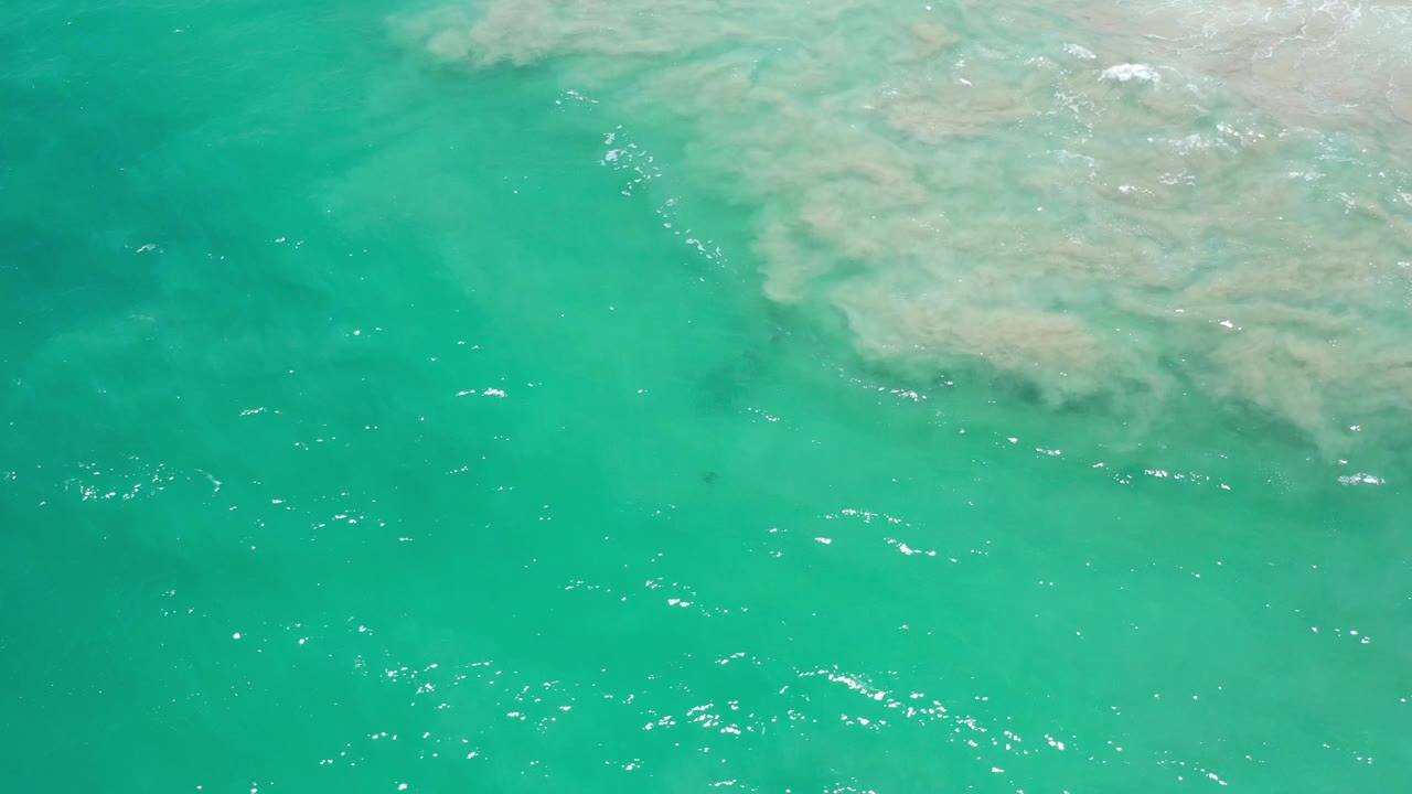 Turquoise sea with foam band in upper right