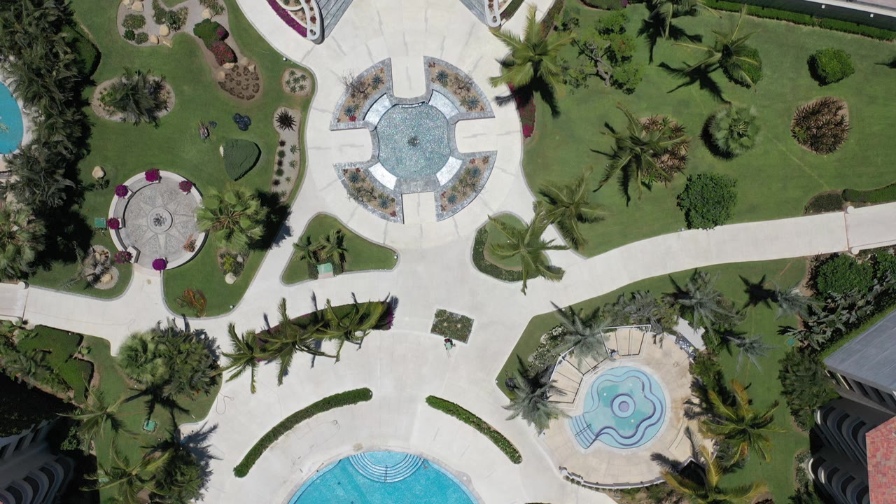 Top-down view of landscaped green space with pools and paths.