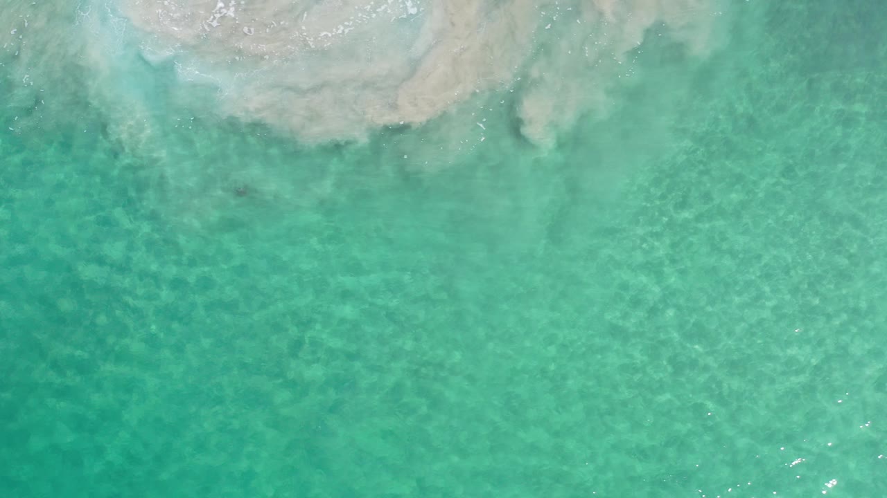Aerial view of shallow turquoise sea with faint ripples