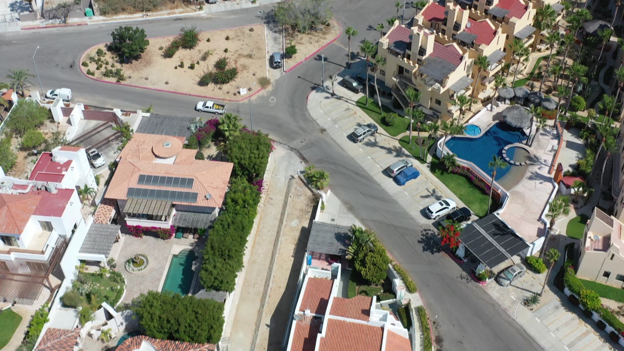 Aerial view of residential streets, homes, pools, and desert landscaping.