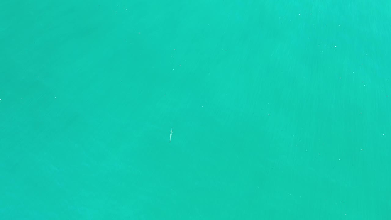 Turquoise-green water in Los Cabos, Mexico, appears slightly lighter through the center with no shoreline or visible people.