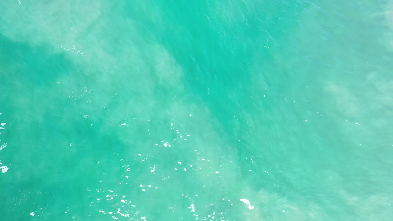 Bright turquoise water with a darker central patch and tiny highlights.