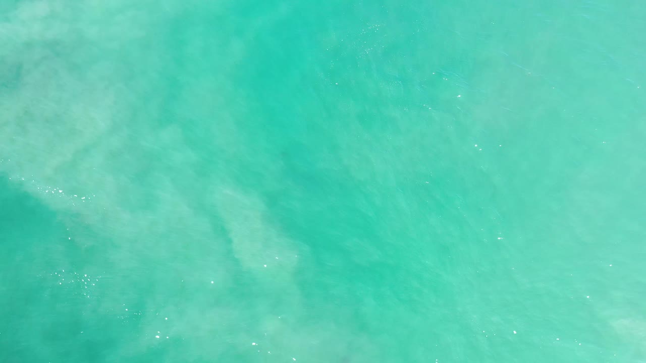 Clear aqua ocean water fills the frame in Los Cabos, Mexico, with soft ripple lines and no visible people.