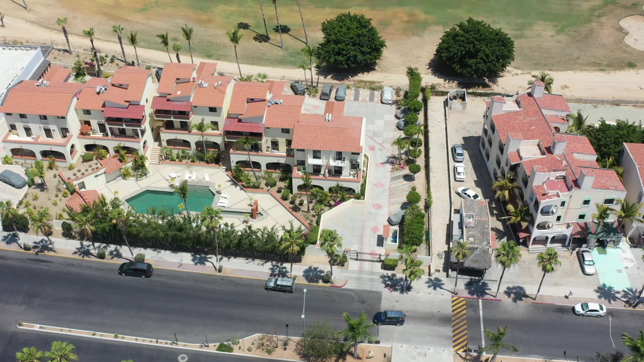 Overhead view of a hotel pool courtyard beside a road.