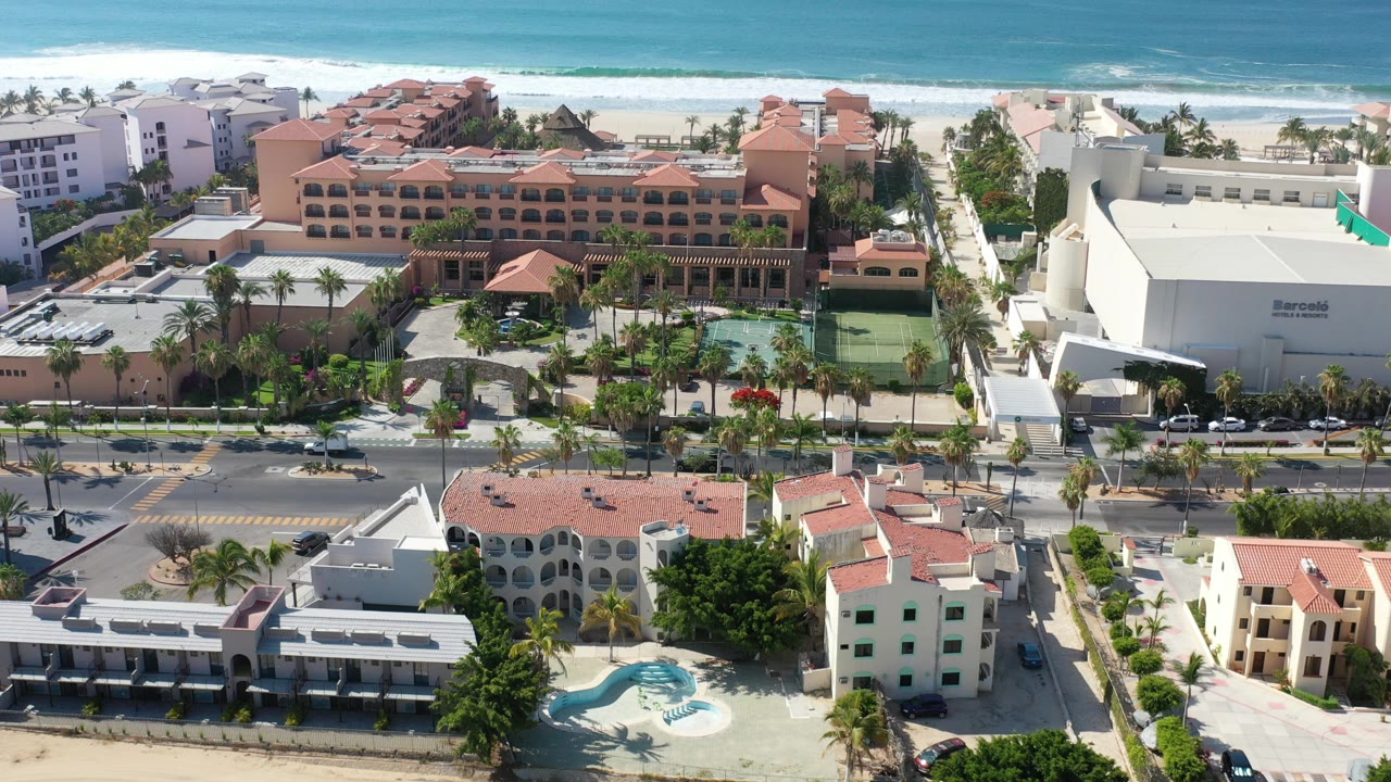 Aerial view of beachfront resort blocks with surf in the background.