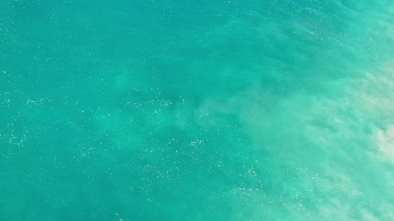 Turquoise water with brighter foamy wash near the upper right.