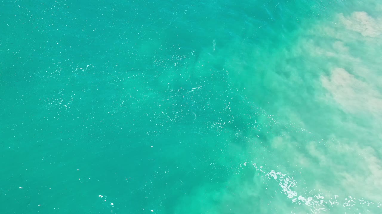 Turquoise water with a brighter foamy patch near the right side.