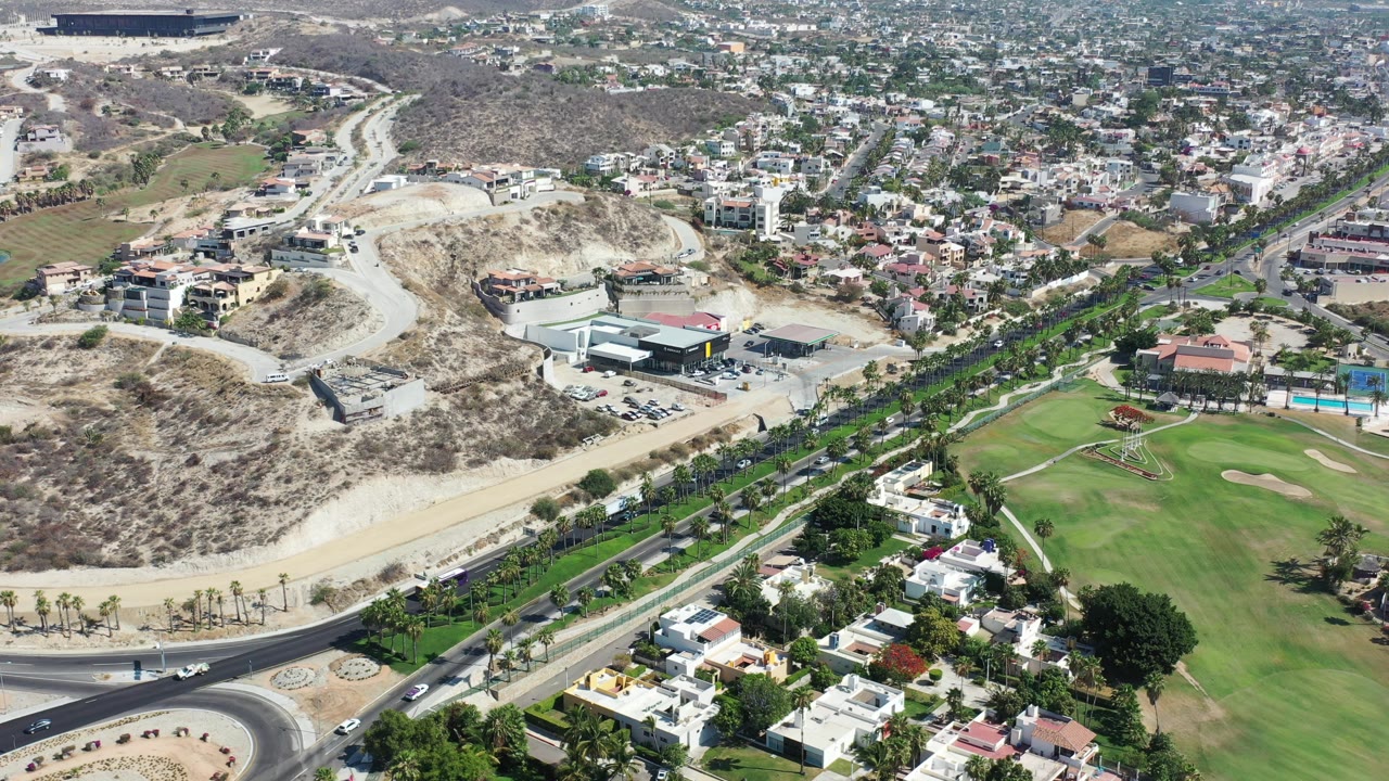 Aerial view of hillside roads, homes, and a green golf course.