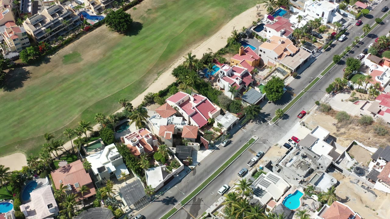 Aerial view of homes beside a green course and road