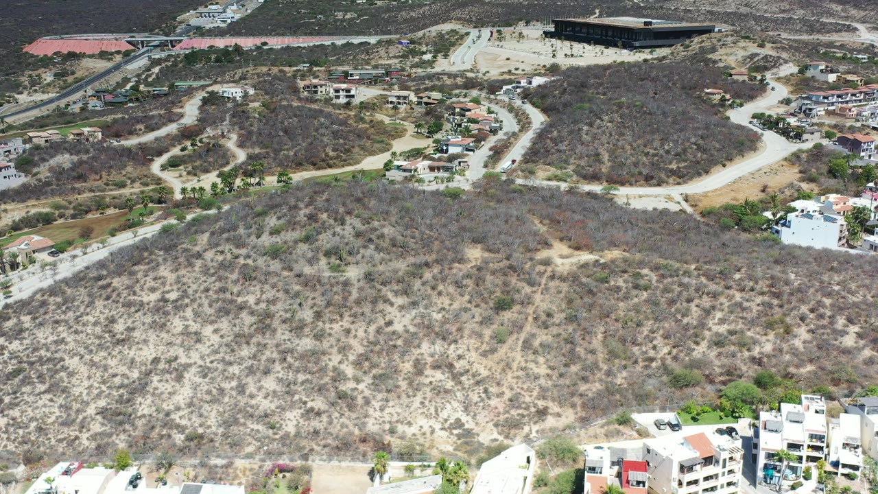 Aerial view of dry foothills above hillside homes and roads.