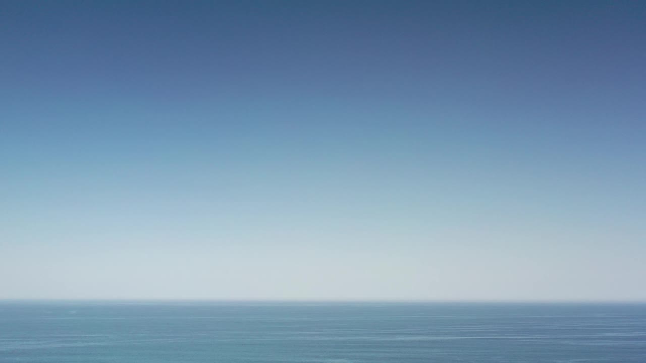 Opening frame of the Los Cabos ocean view, showing a broad blue sea beneath a clear sky with no visible people.