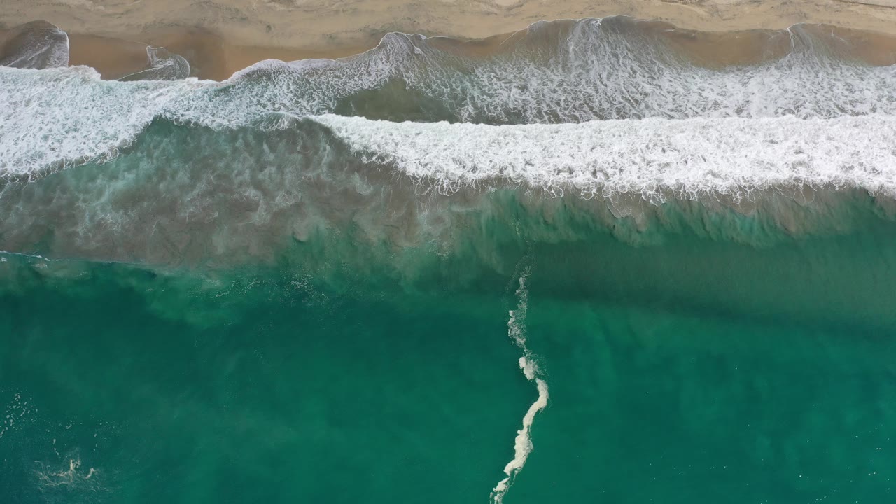 Breaking wave parallel to a narrow sandy shoreline
