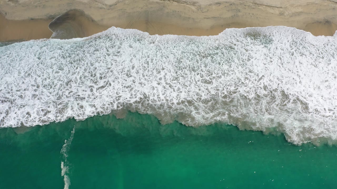 Breaking surf spread between beach and open water
