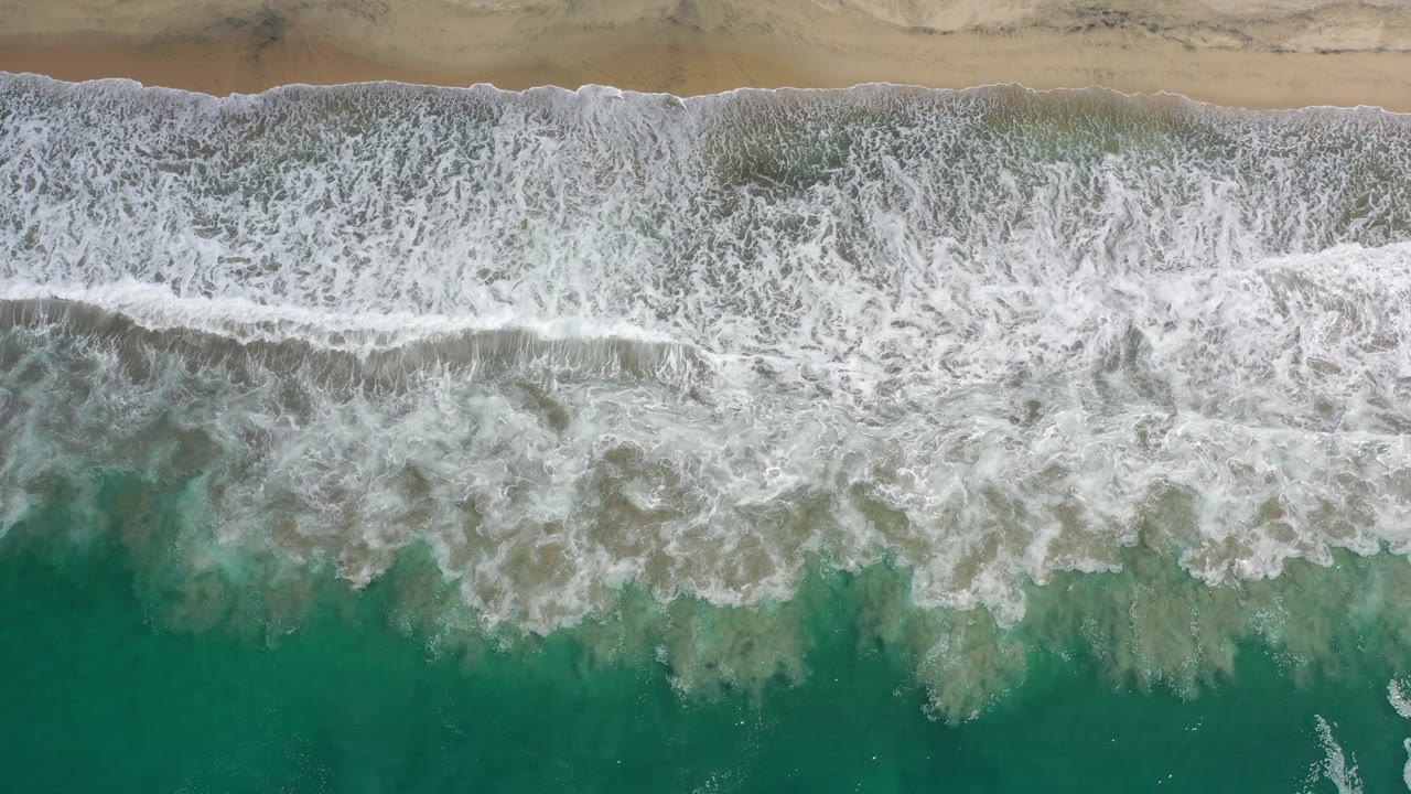 Aerial shoreline with surf and wet sand