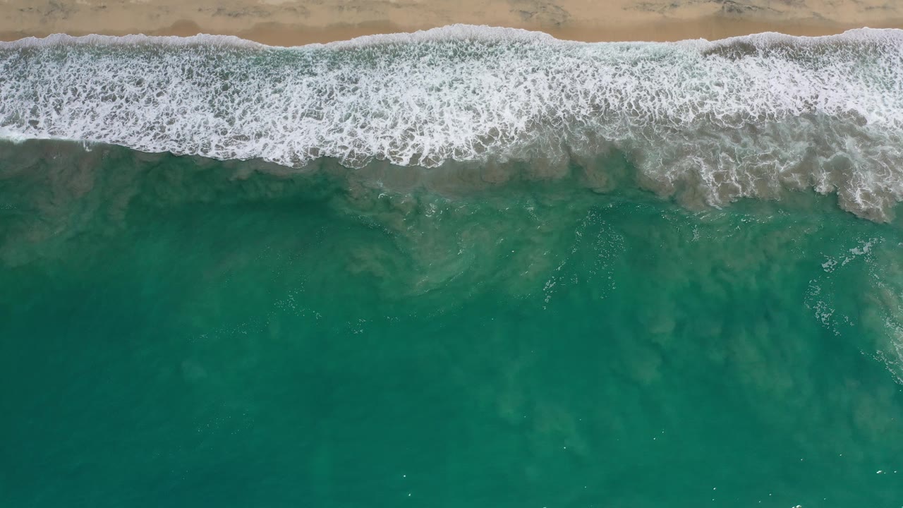 Aerial view of foamy surf and green water