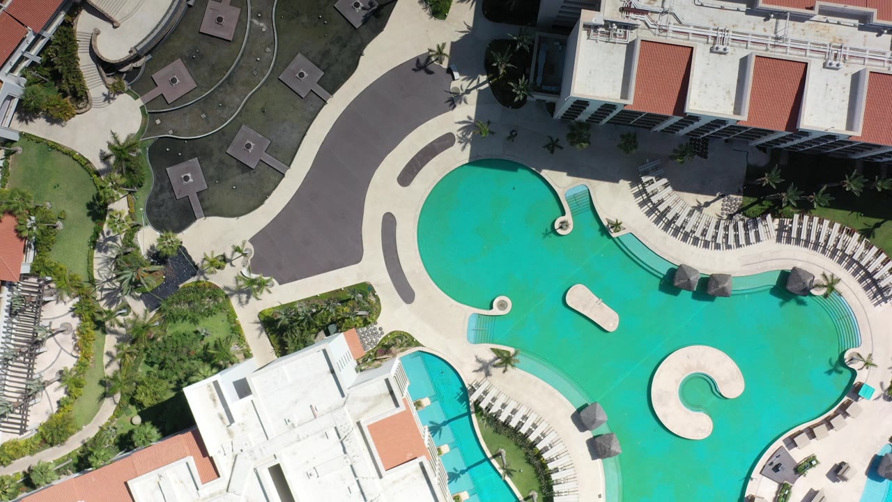 Overhead resort pool with white buildings and red roofs