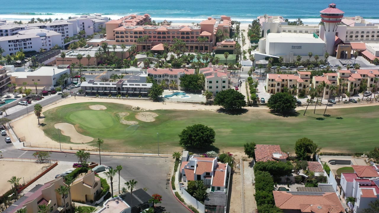 Aerial view of resort buildings, golf course, and ocean coastline.