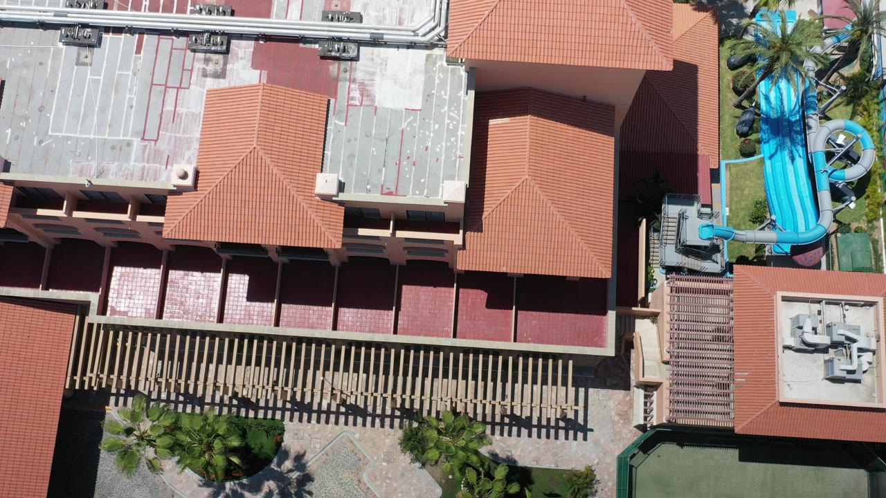 Overhead roof complex with water slides at the edge and palm landscaping.