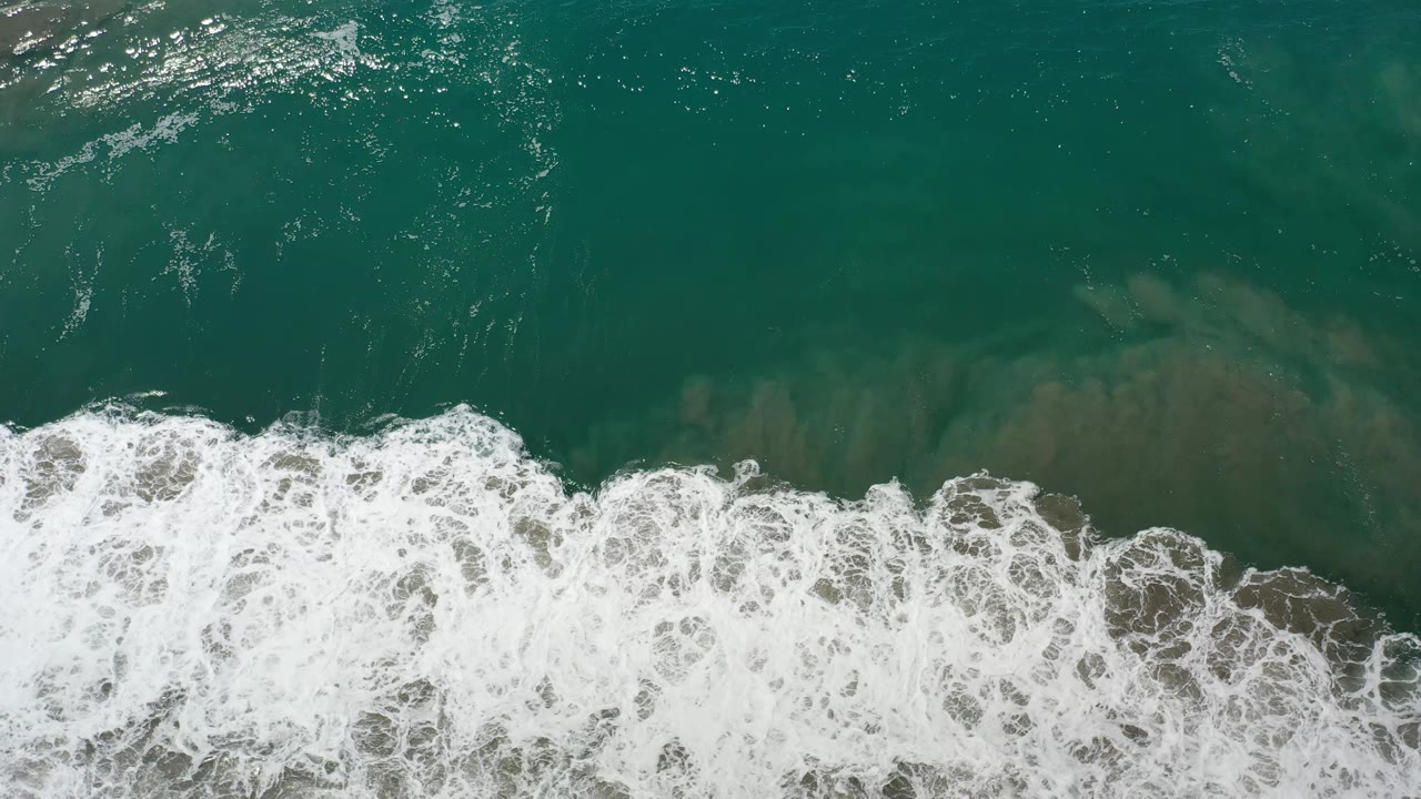 A broad white wave band spreads through the lower half of the overhead Los Cabos ocean frame, with no visible people.