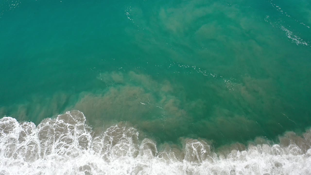Overhead cyan surf with white foam along the bottom edge.