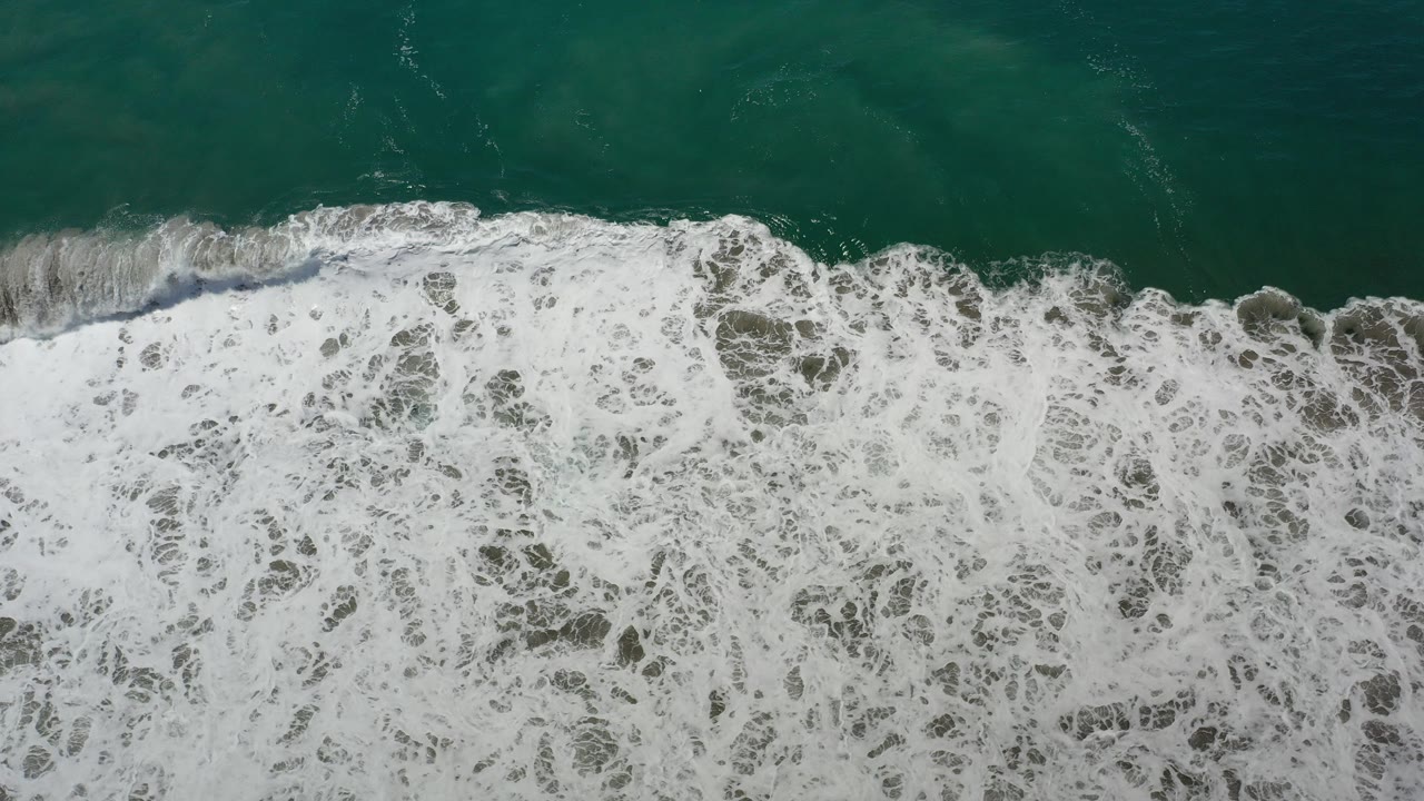 Overhead teal water and white surf band