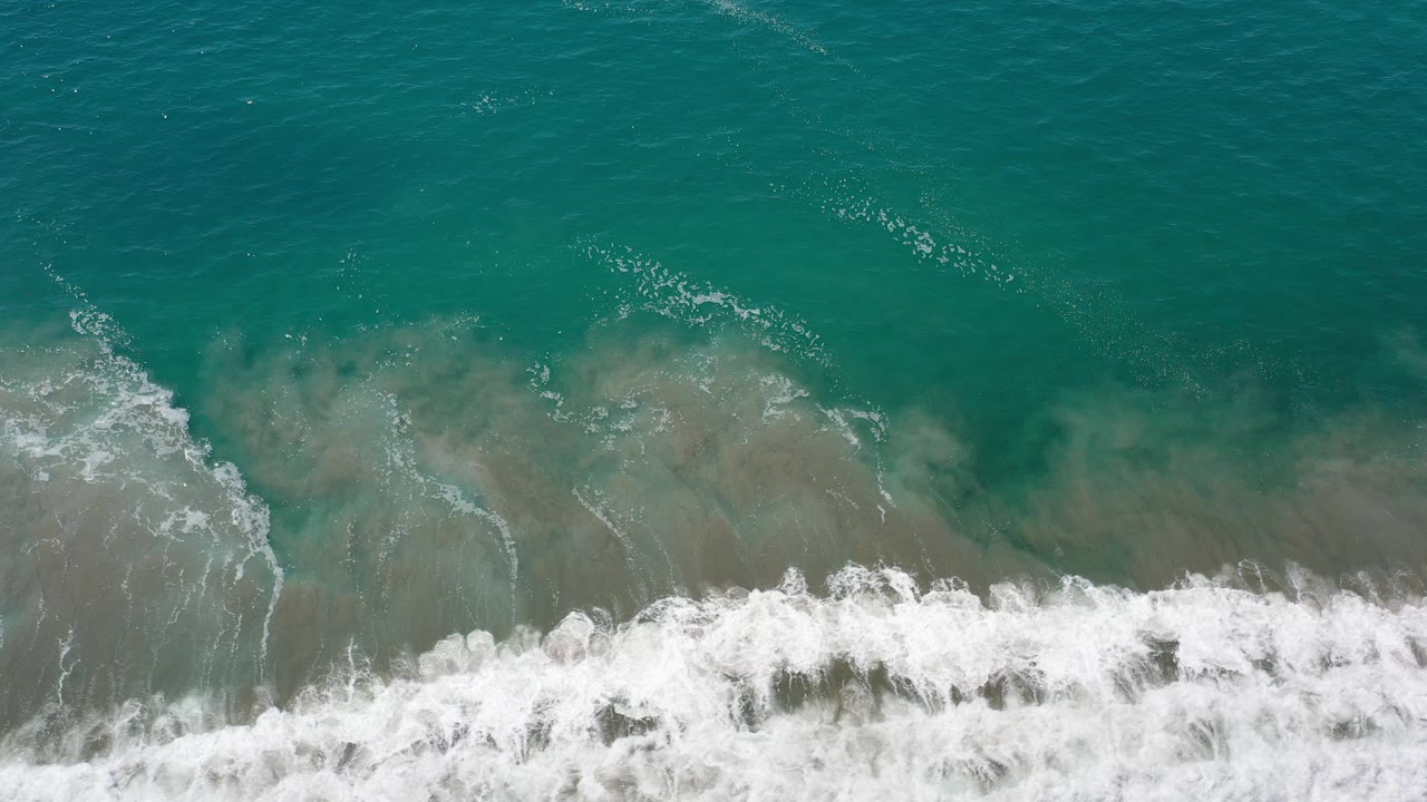 Overhead turquoise sea with white surf along the lower edge.