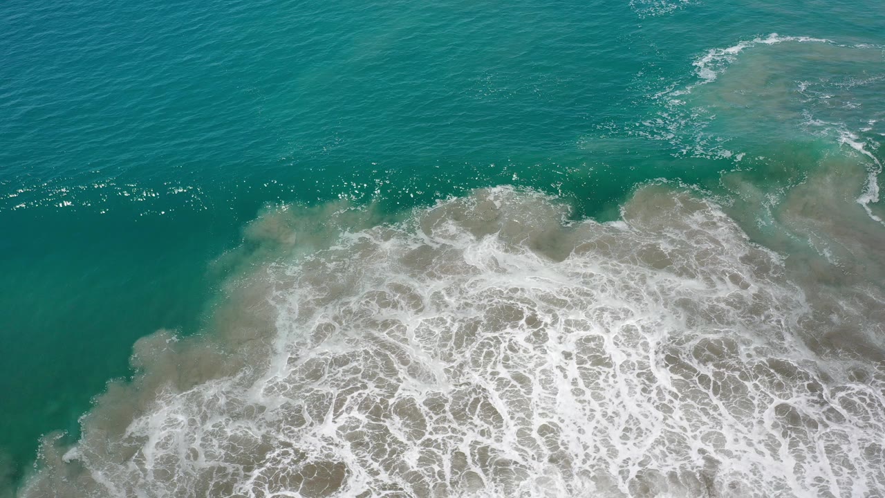 Breaking surf line in green sea