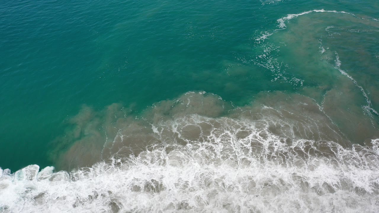 Overhead green ocean water with white surf at the bottom edge.