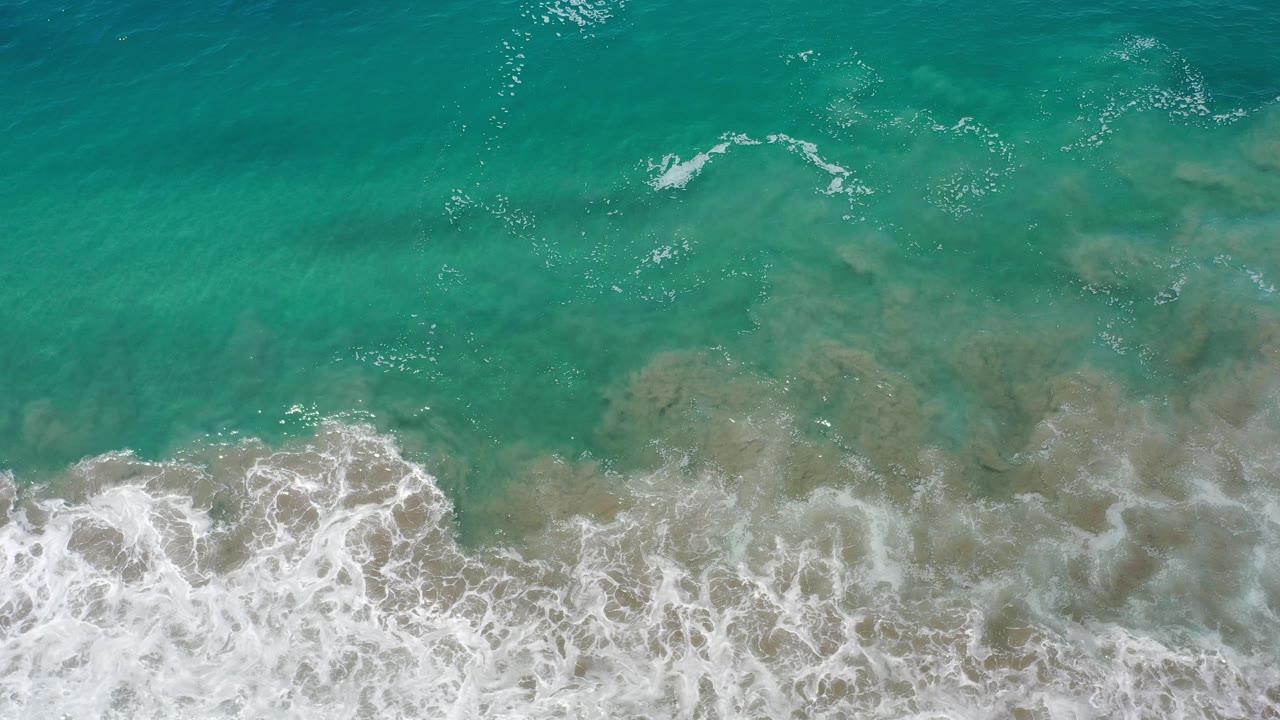 Overhead turquoise water with white surf along the bottom edge.