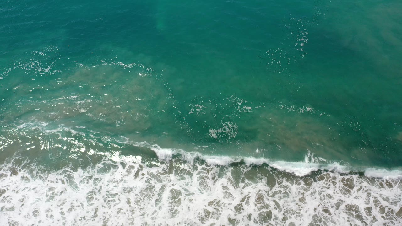 Overhead green ocean water with white surf at the bottom edge