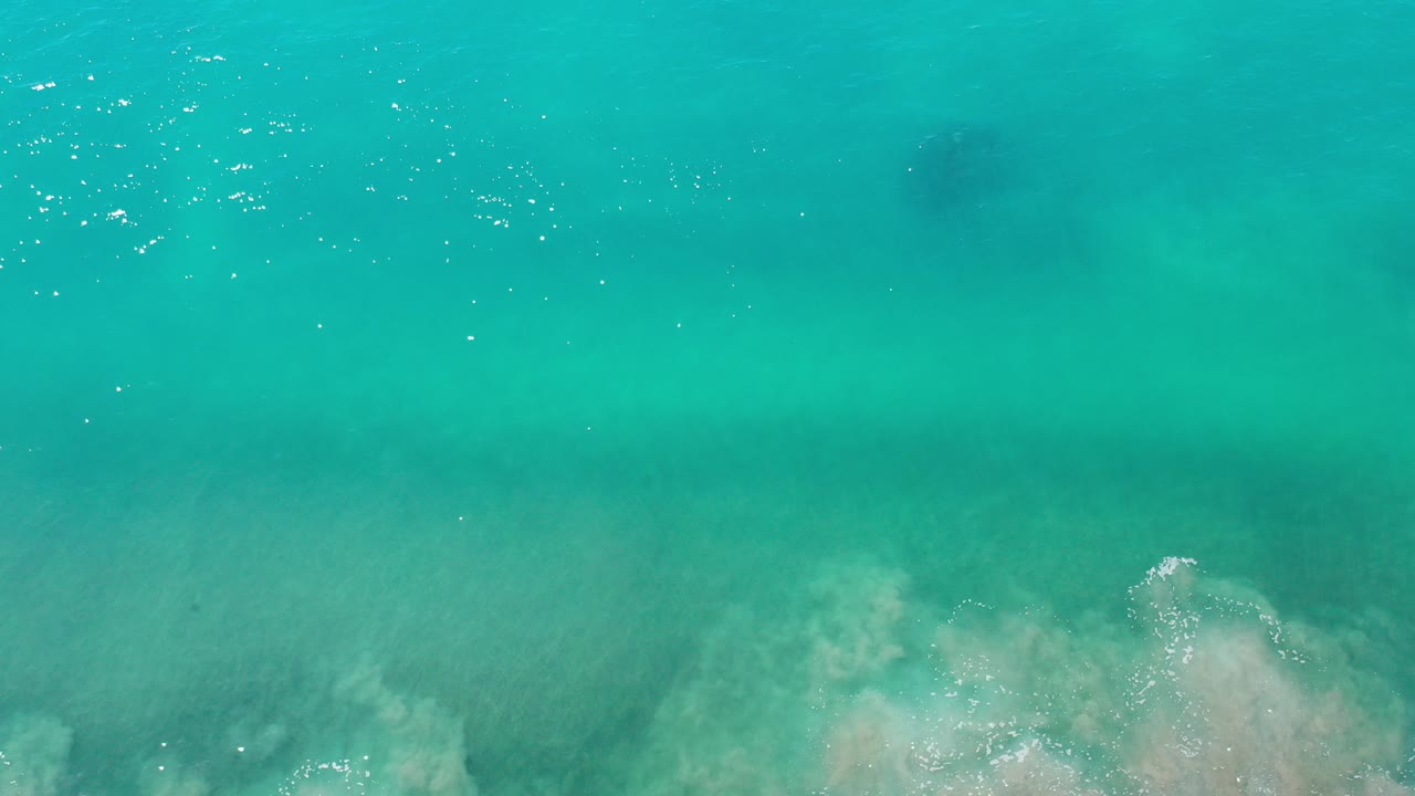 Turquoise ocean water with pale surf at the lower edge