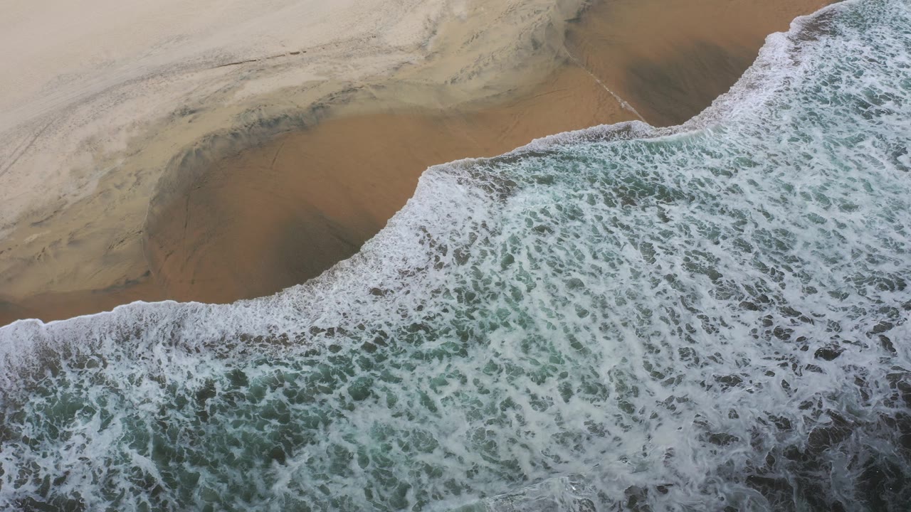 Breaking wave beside empty beach