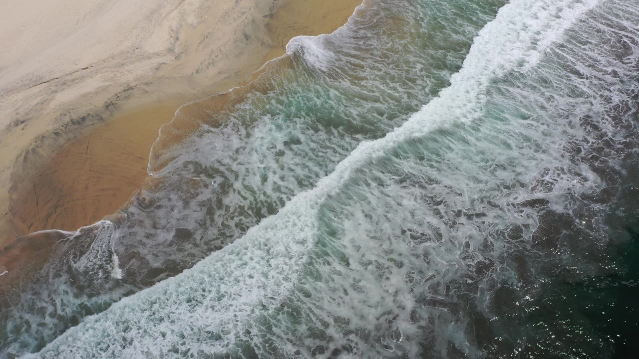 Foamy wave band crossing green water